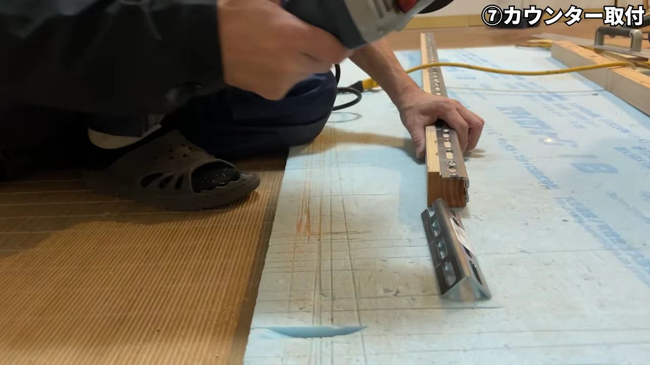 洗面カウンターの裏側に金具を取り付ける作業風景